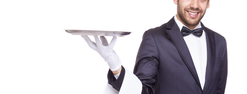 Smiling waiter holding an empty silver tray, isolated on white background