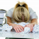 a young woman desperately in office between many file folders and crumpled papier.symbolfoto for str