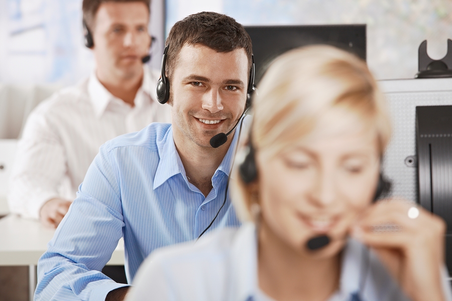 Young customer service operator talking on headset, smiling. Customer Service and Support Outsourcing