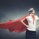 Young confident woman in red cape and mask