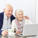 Happy senior citizen couple using social media